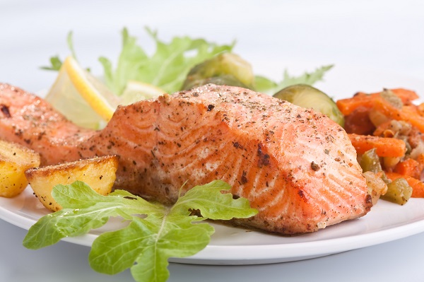 healthy salmon with vegetables on white plate