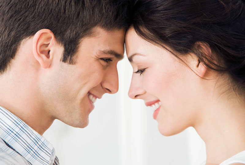 Young couple smiling at each other, close up