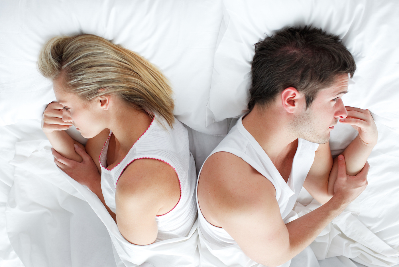 Couple lying separately in bed after having a fight. Marriage trouble
