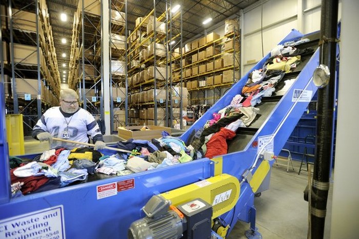 Wed. , Feb. 8, 2012. Ron Moran feeds a baler inside Goodwill's new warehouse and buy the pound outlet store at the Gorham Industrial Park. (Photo by John Patriquin/Portland Press Herald via Getty Images)