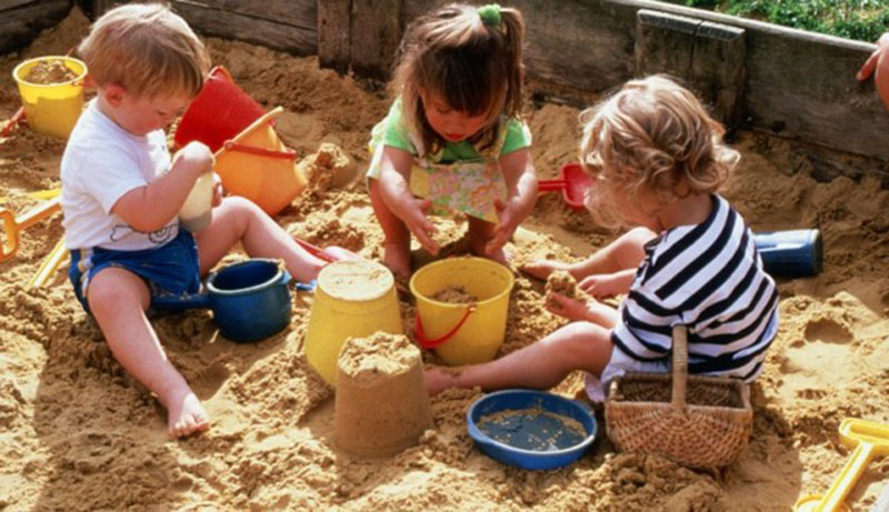 AS0000114FD07 Children, in park and adventure playground Credit: Anthea Sieveking . Wellcome Images images@wellcome.ac.uk http://images.wellcome.ac.uk Two girls and a boy playing together in a sandpit. They are building a sand castle with buckets and spades. Photograph Published:  -  Copyrighted work available under Creative Commons by-nc-nd 2.0 UK, see http://images.wellcome.ac.uk/indexplus/page/Prices.html